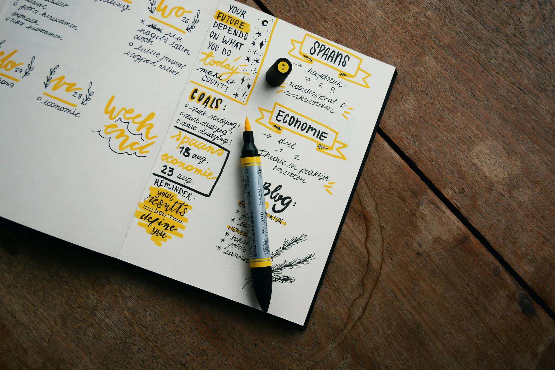 Printed planner pages, a notebook and a pen laid out ready for content planning