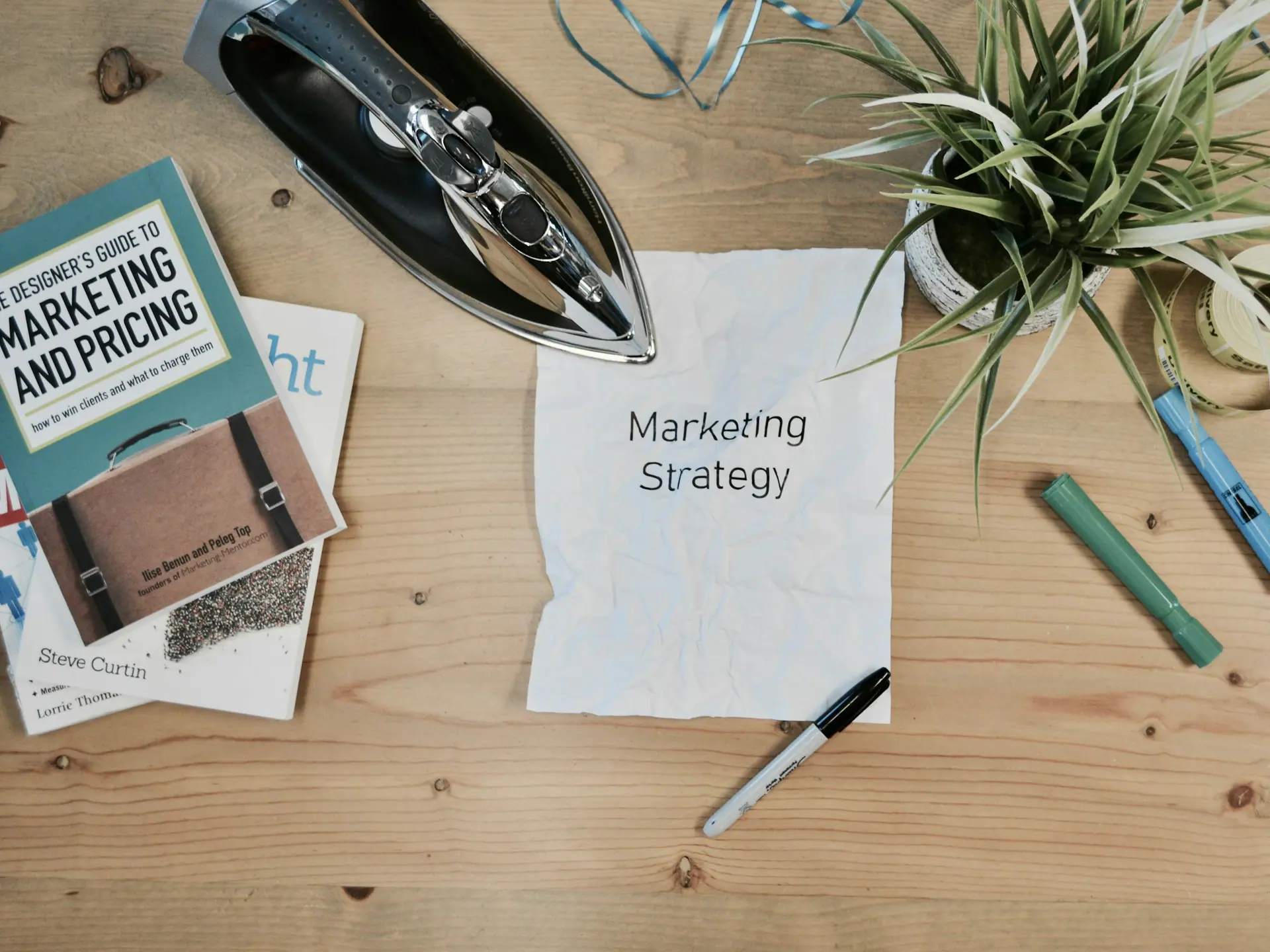 Marketing strategy notes, a notebook and pens arranged on a pale desk